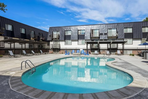 A swimming pool in front of a building with a black and white exterior.
