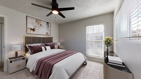 A bedroom with a large bed and a ceiling fan.