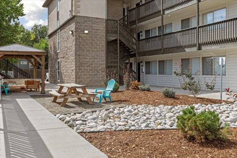 A patio area with a table and chairs is in front of a building.