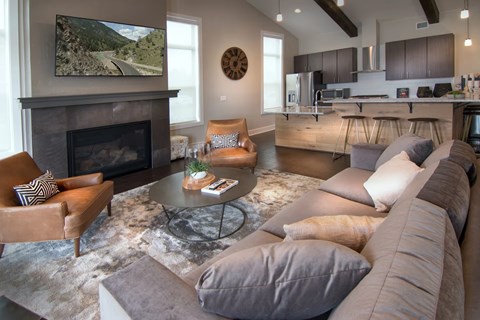 A living room with a fireplace and a television on the wall.