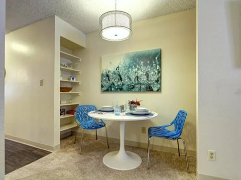 A dining room with a white table and blue chairs.