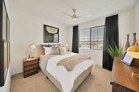 A bedroom with a large bed and a ceiling fan.
