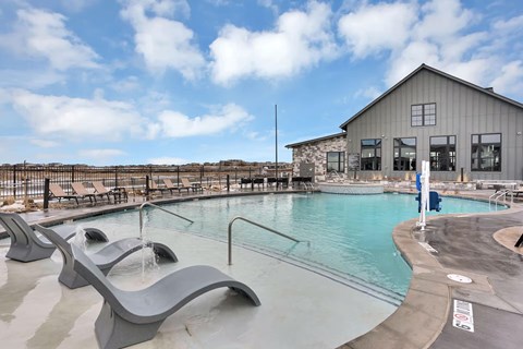 A pool with a slide and a building in the background.
