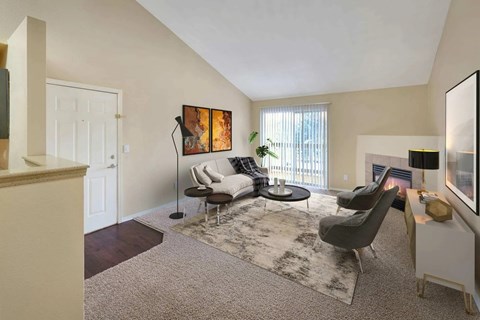 A living room with a grey rug and a grey chair.