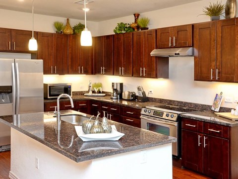 A kitchen with brown cabinets and a granite countertop.