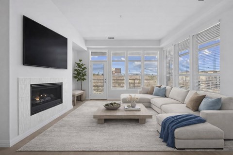 A modern living room with a fireplace and a large window.
