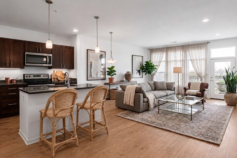 A modern kitchen with a dining area and a living room.