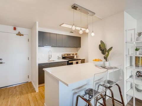 A kitchen with a white counter and a white fridge.