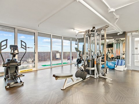 A well-equipped gym with a variety of machines and a view of the outside.
