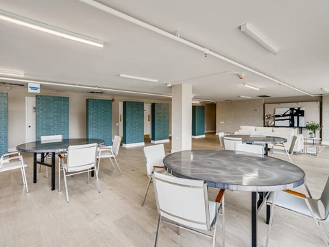 A modern dining room with a large table and chairs.