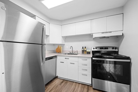 A modern kitchen with a stainless steel refrigerator and stove.