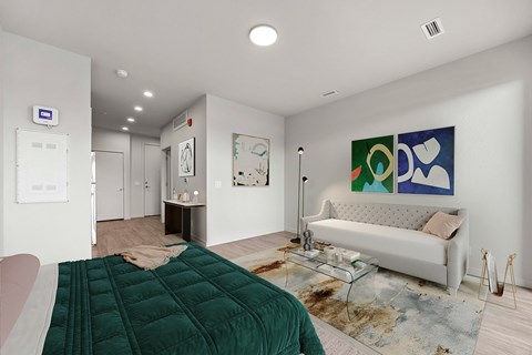 A bedroom with a bedspread on the bed and a couch in the room.