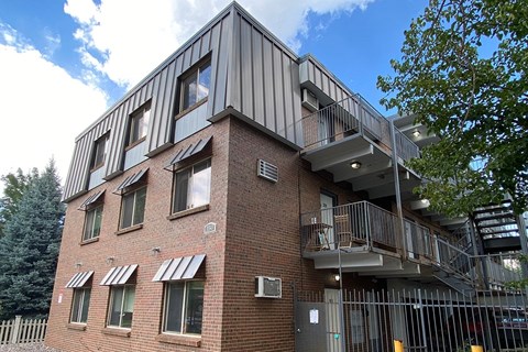 A modern building with a balcony and a gate.