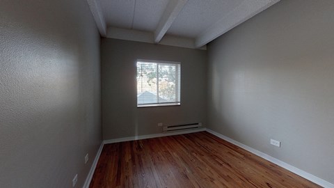 A room with wooden floors and a window letting in light.