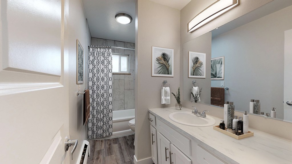 A bathroom with a white sink and a shower with a glass door.