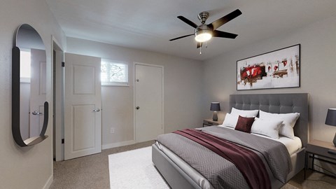 A bedroom with a large bed and a ceiling fan.