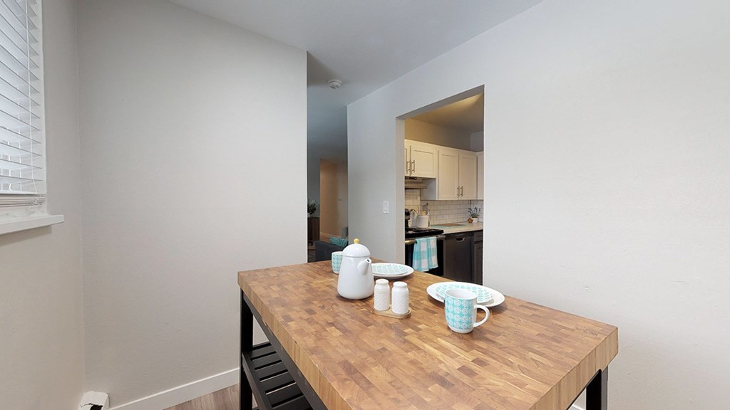 A kitchen with a table in the foreground.