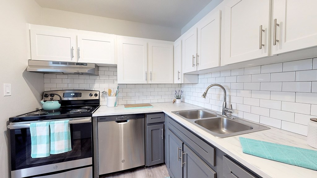A kitchen with a stove, oven, and sink.