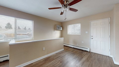 A room with a ceiling fan and a window with blinds.