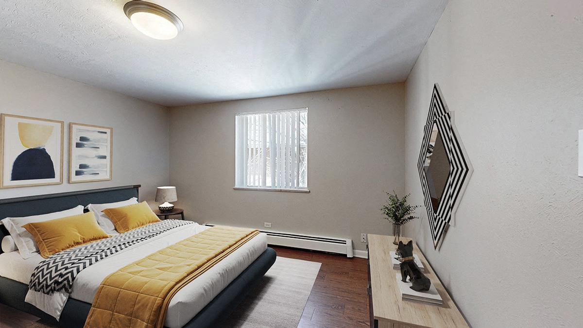 A bedroom with a bed, nightstand, and a window with blinds.