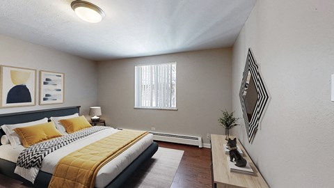 A bedroom with a bed, nightstand, and a window with blinds.