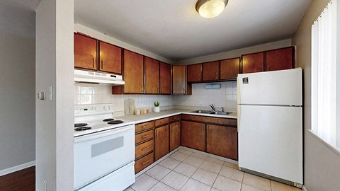 A kitchen with white appliances and wooden cabinets.