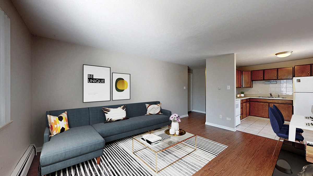 A living room with a grey couch and a striped rug.
