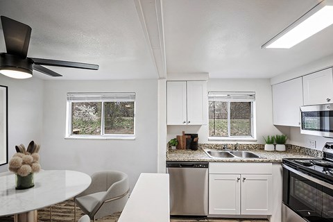A white kitchen with a table and chairs.
