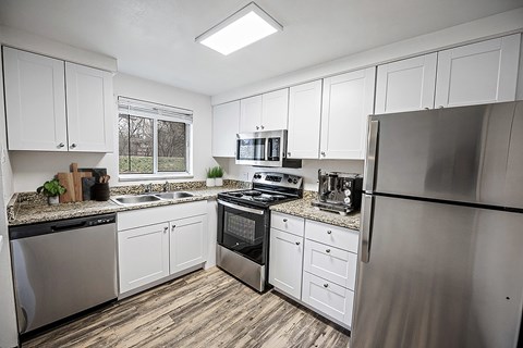 A kitchen with white cabinets and stainless steel appliances.