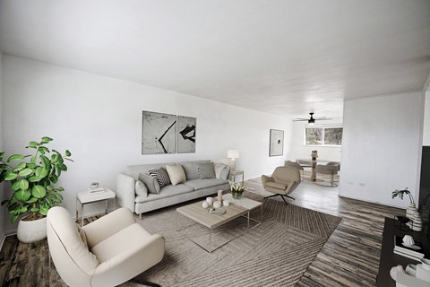 A living room with a couch, chair, and potted plant.