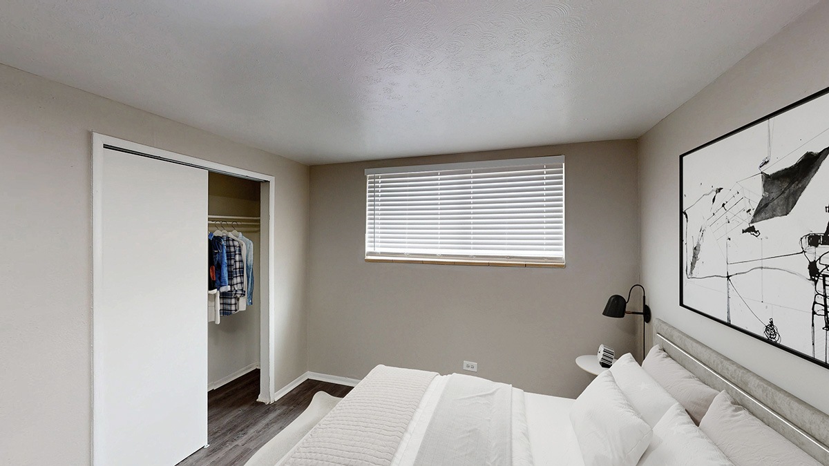 A bedroom with a large bed and a painting on the wall.