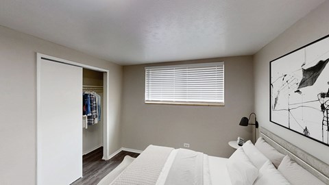 A bedroom with a large bed and a painting on the wall.
