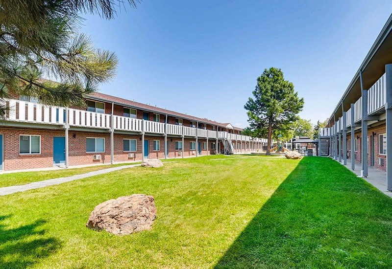 A long building with a green lawn in front.