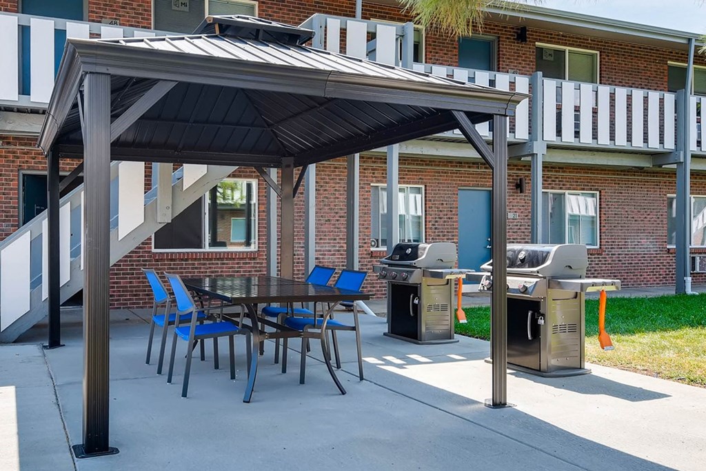 A patio with a table and chairs under a roof.