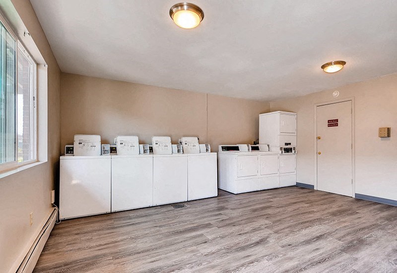 A laundry room with 4 washers and dryers.