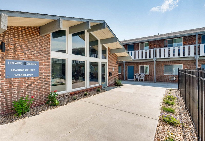 The image shows the front of a brick building with a sign that reads