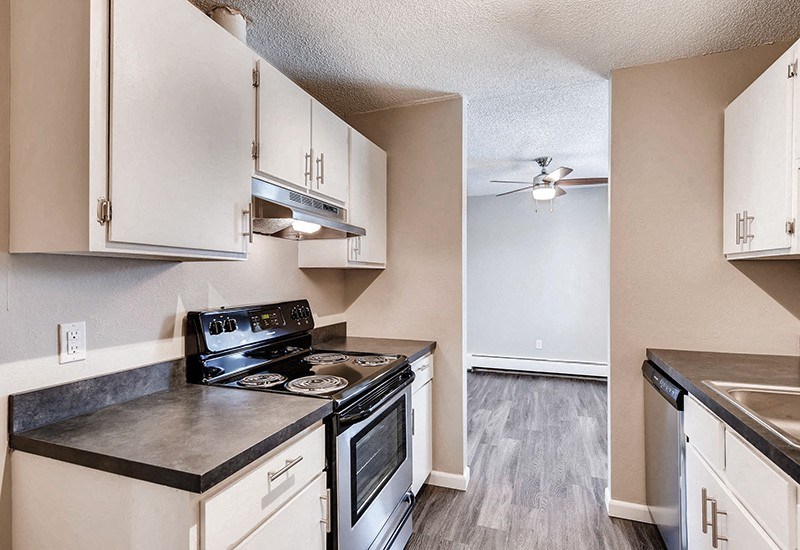 A kitchen with black countertops and white cabinets.