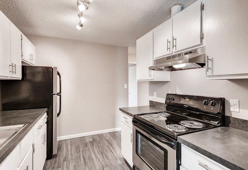 A kitchen with black appliances and white cabinets.