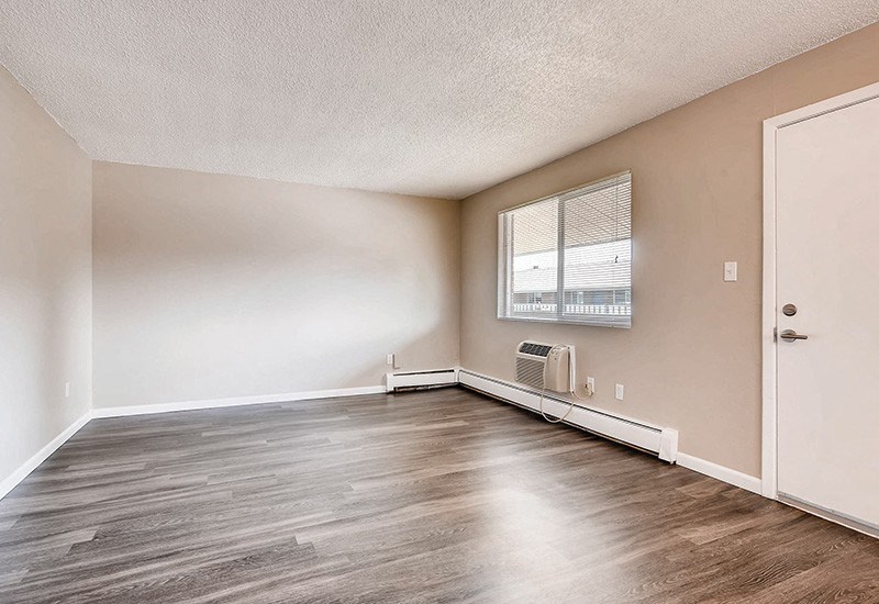 A room with a white door and a window with blinds.