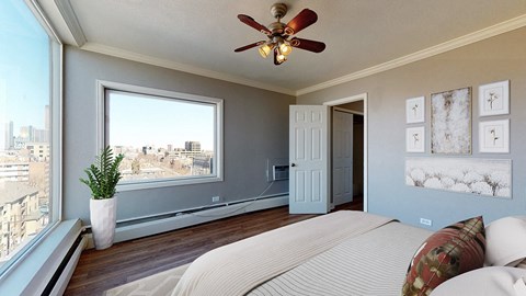 A bedroom with a large bed and a view of the city.