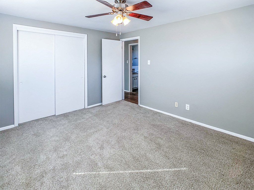 A room with a ceiling fan and two doors.
