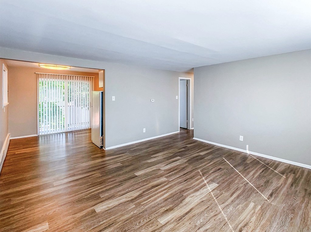 A room with wooden flooring and white walls.