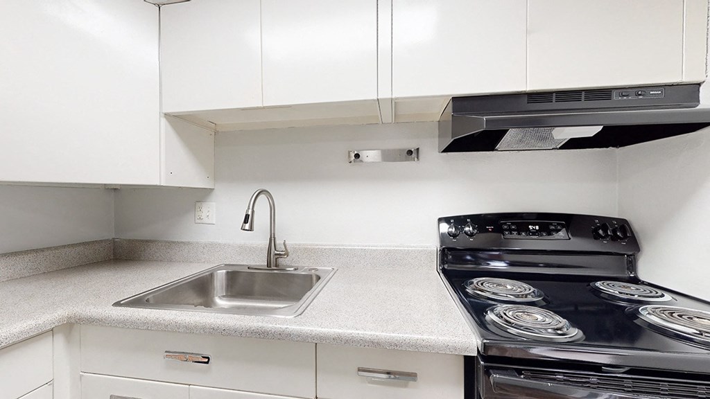 A modern kitchen with a black stove top oven.