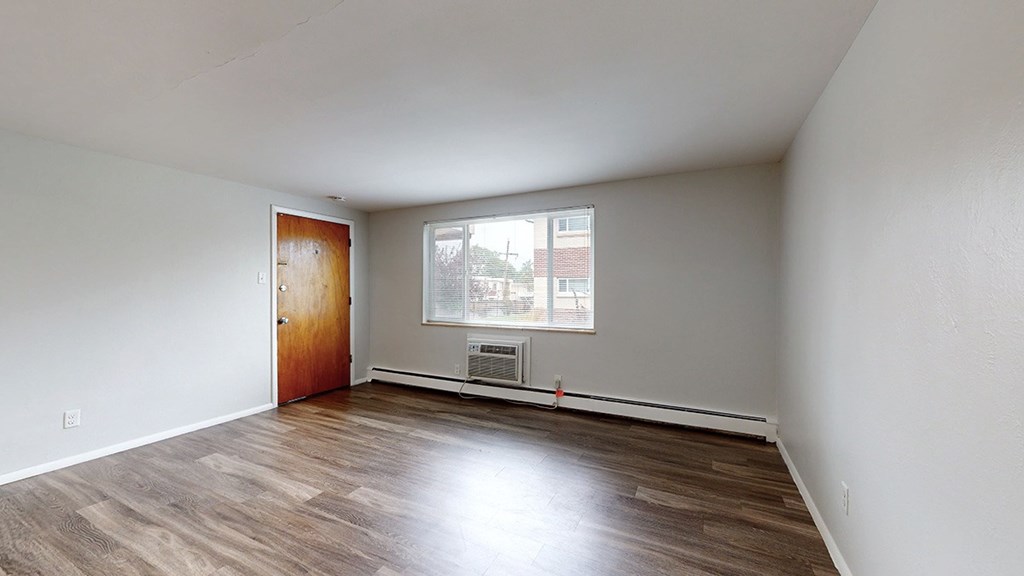Empty room with wooden floors and white walls.