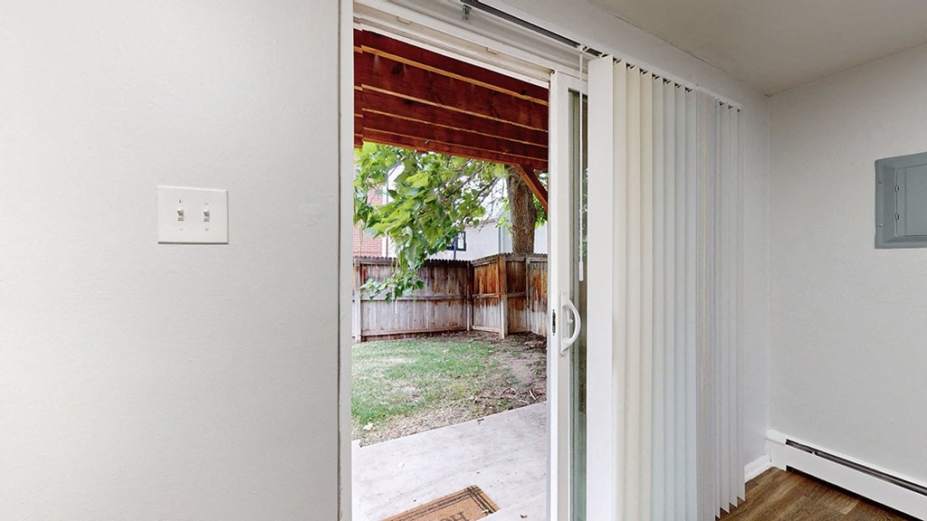 A white door with a window and a light switch on the wall.