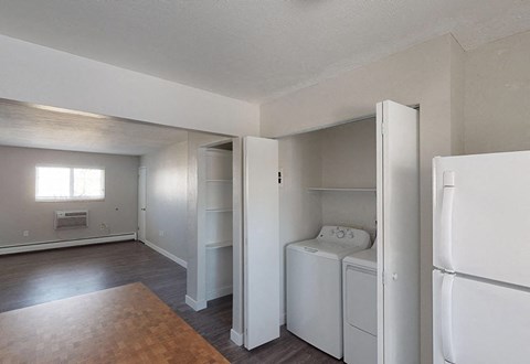 A white bedroom with a washer and dryer built into the closet.