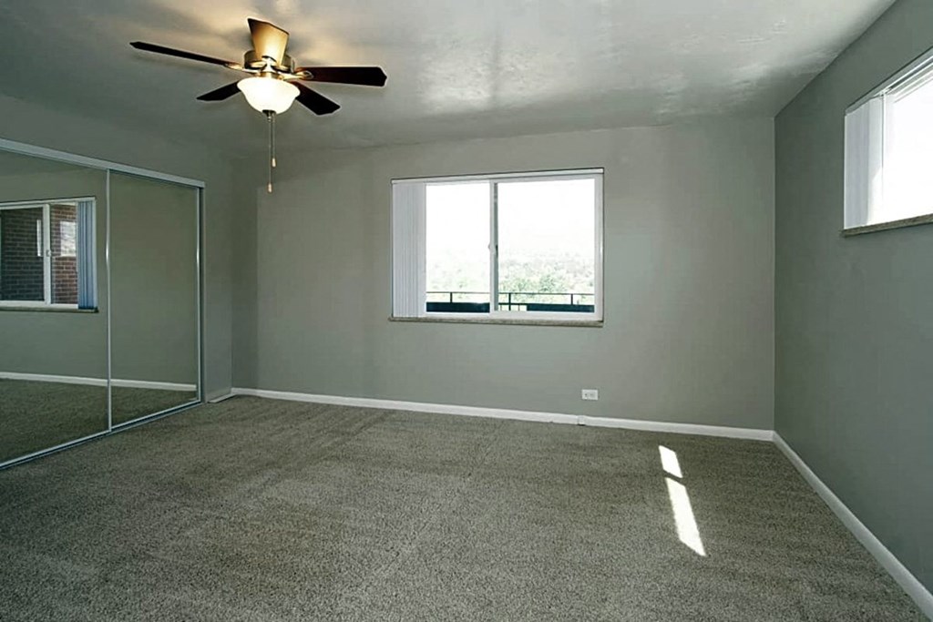 A room with a ceiling fan and a window.
