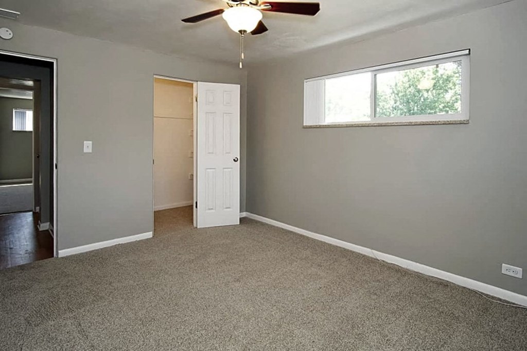 A room with a ceiling fan and a window.