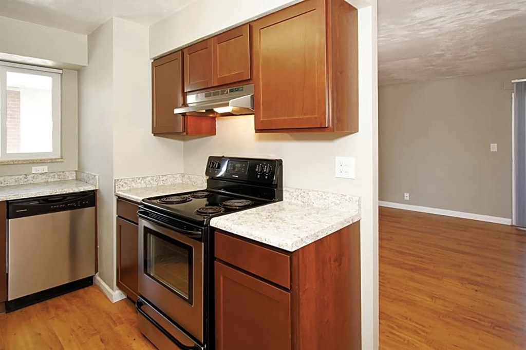A kitchen with wooden cabinets and a black stove top oven.