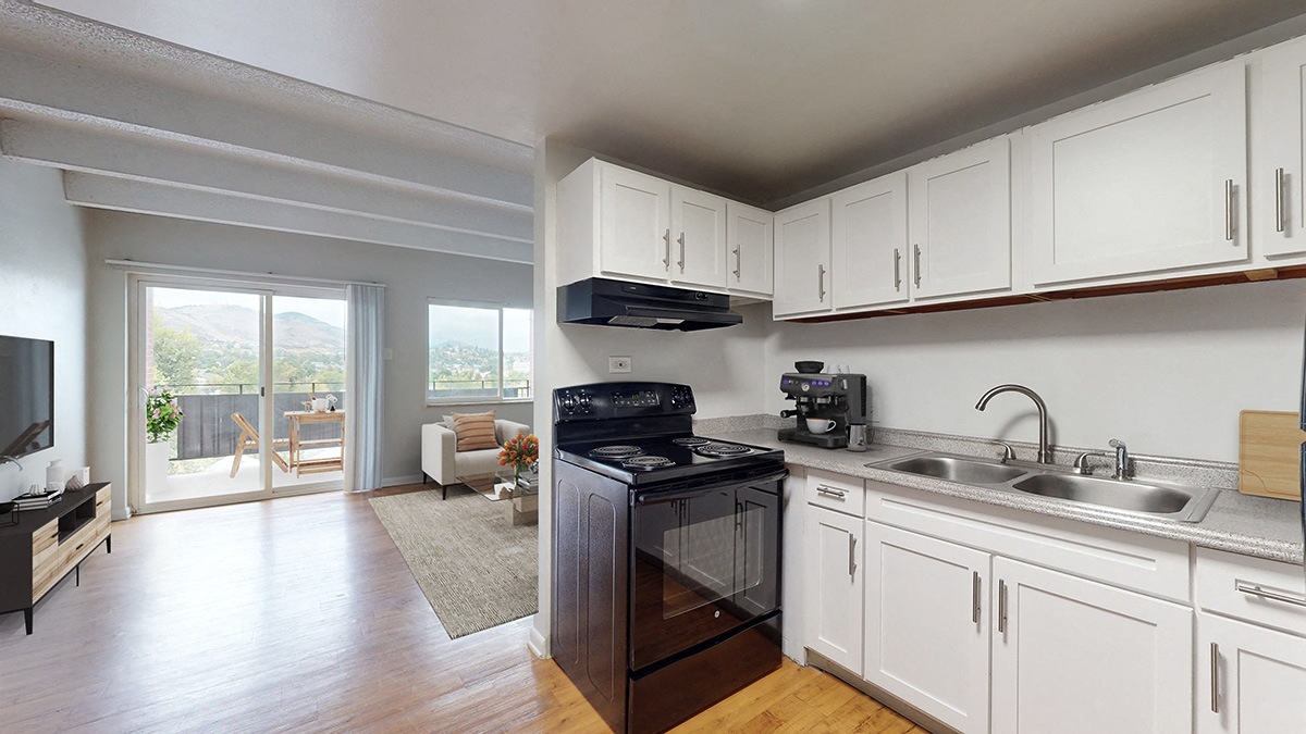A kitchen with white cabinets and a black stove top oven.